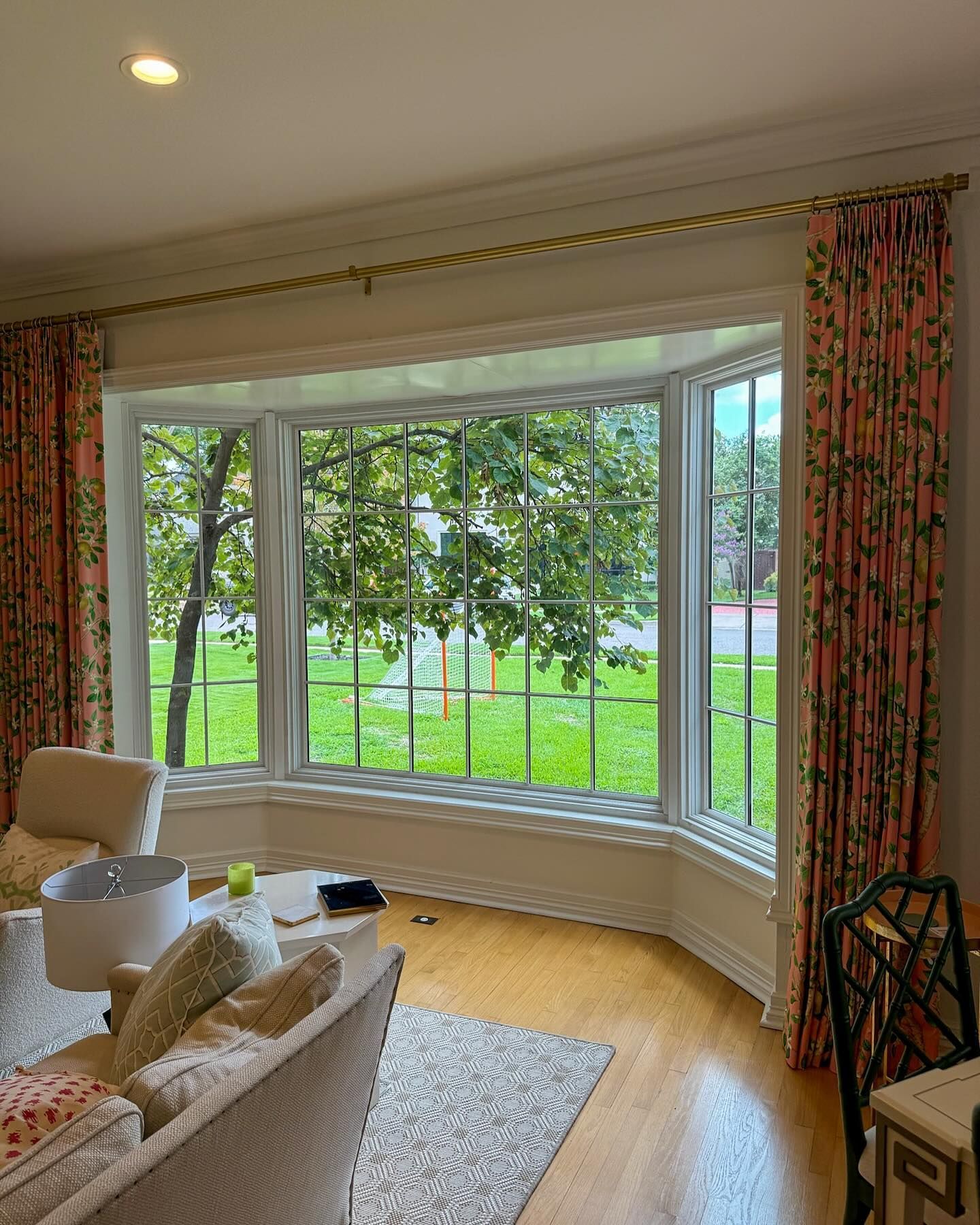A living room with a large bay window and a couch.