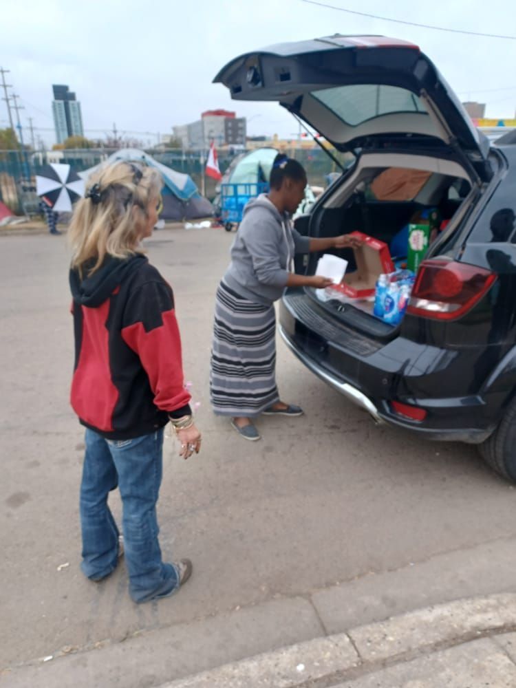 a woman is loading boxes into the back of a car