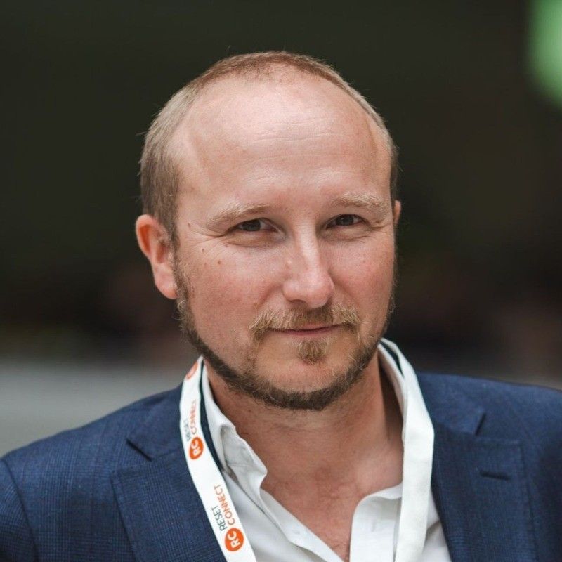 A man with a beard wearing a lanyard.