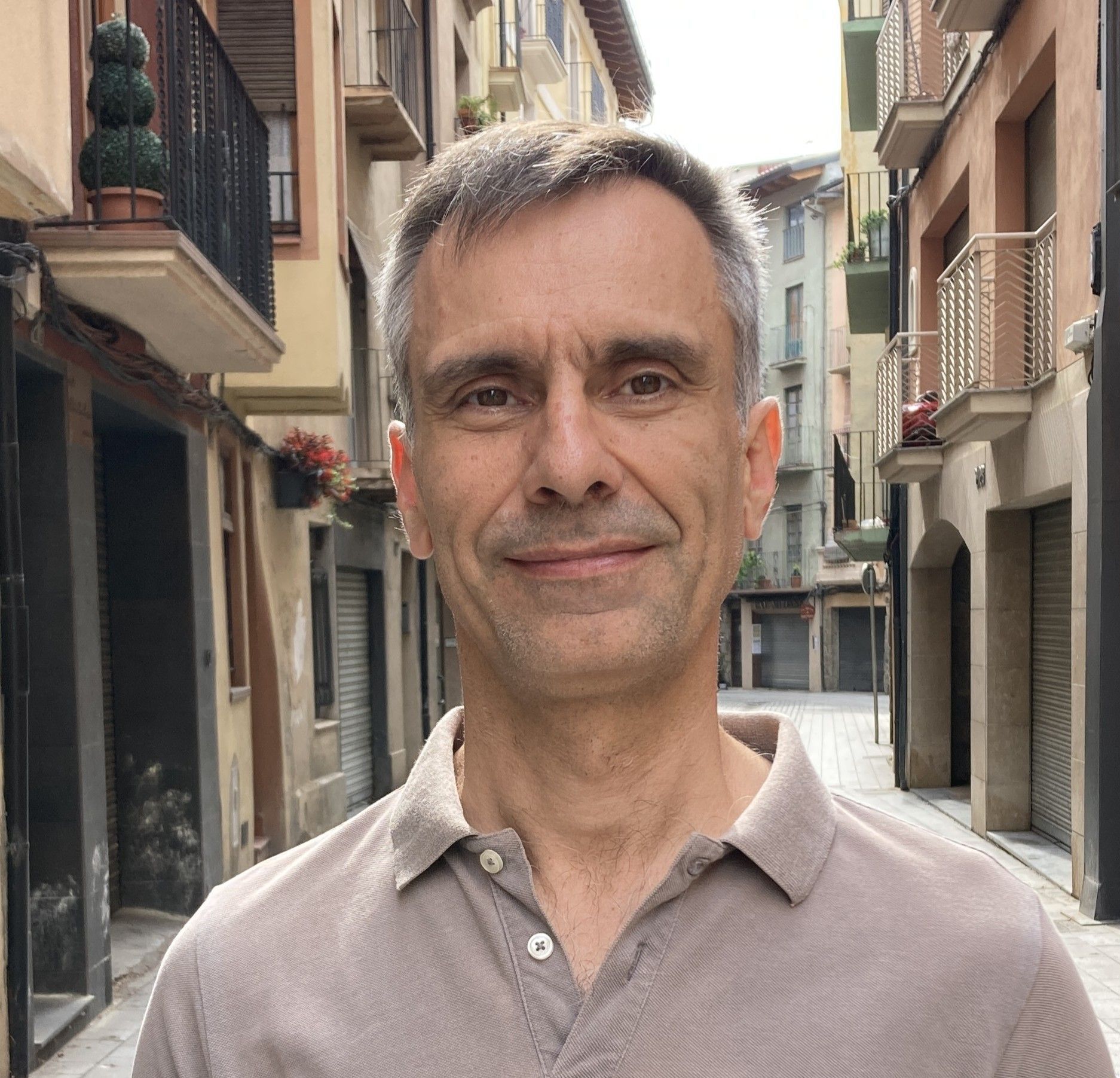 A man in a polo shirt is standing in a street.