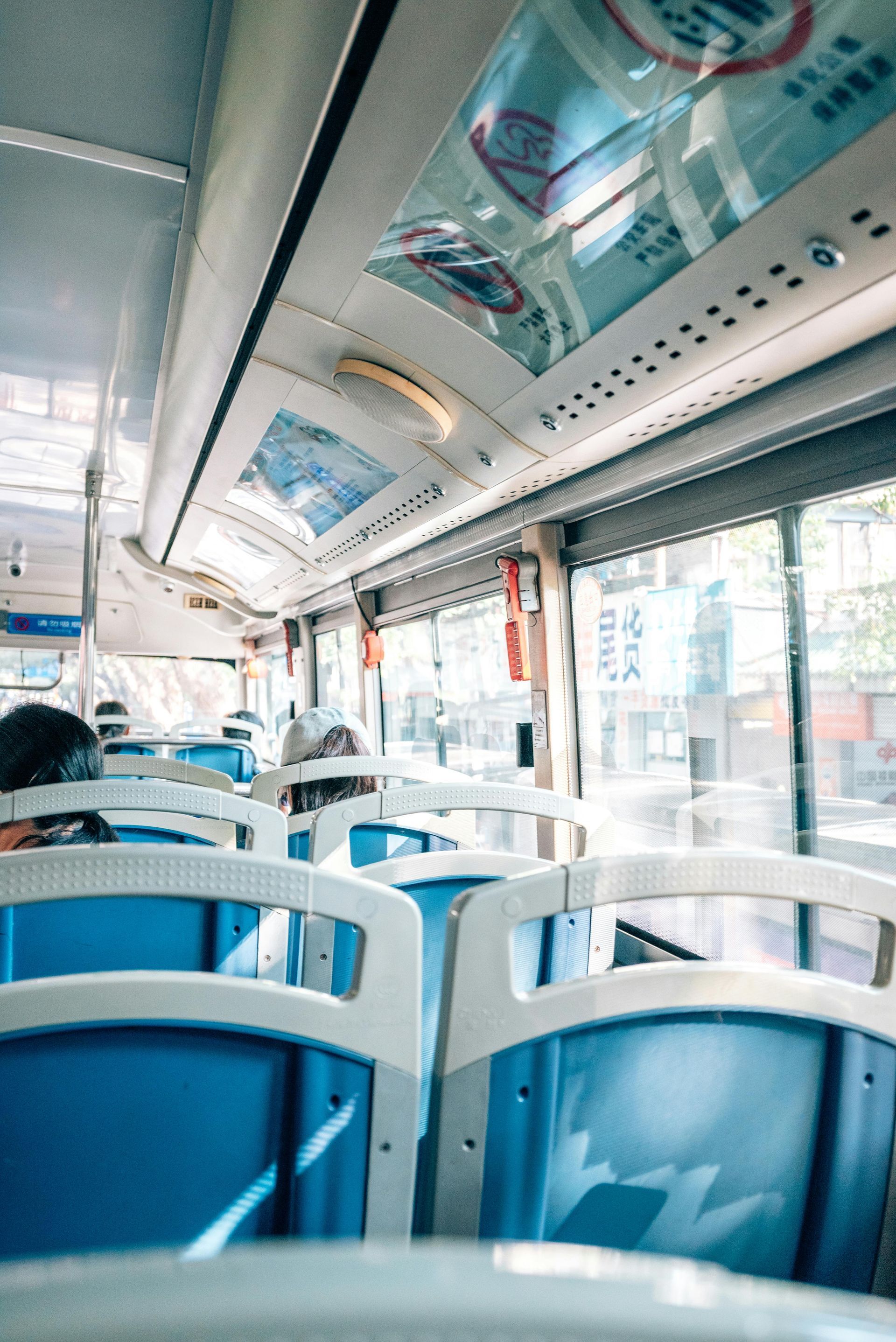 The inside of a bus with blue seats.