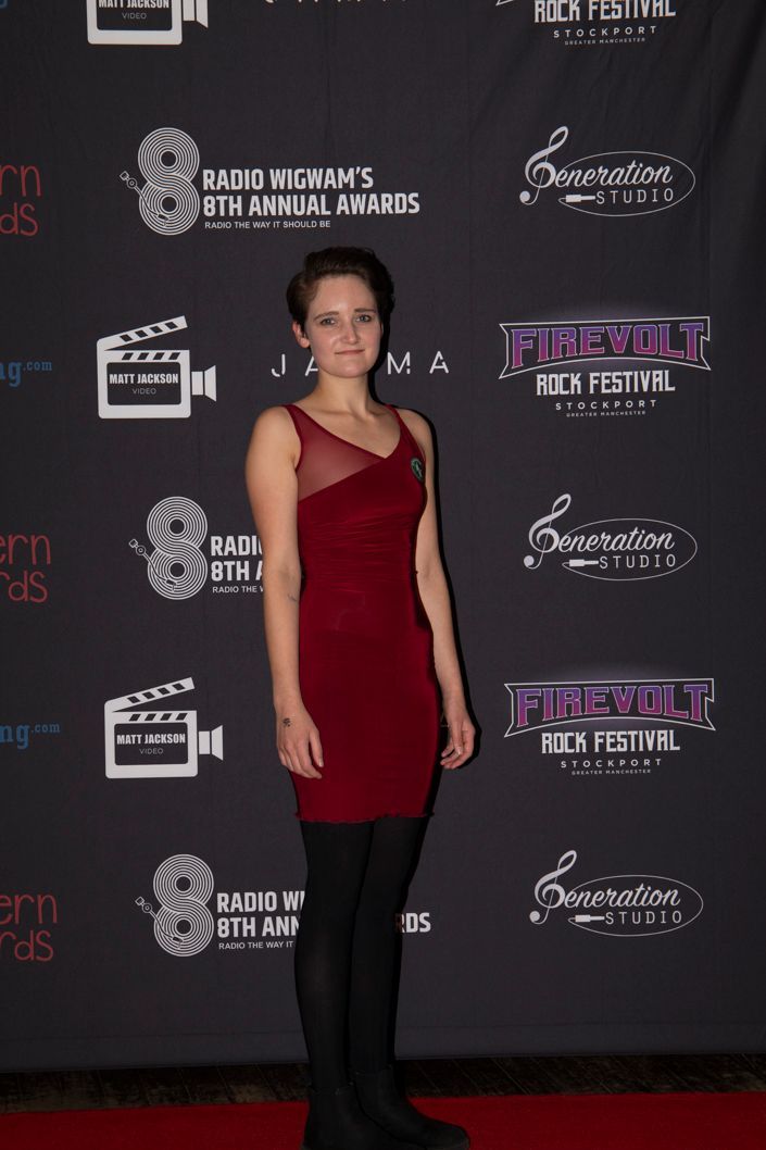 Nina Condron in red dress and black tights at the Radio wigwam Awards show on the red carpet with