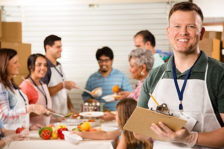 A man is holding a clipboard in front of a group of people.