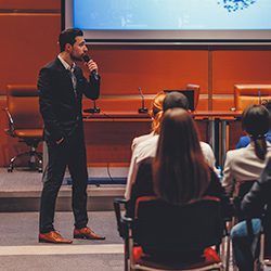 A man is giving a presentation to a group of people in a conference room.