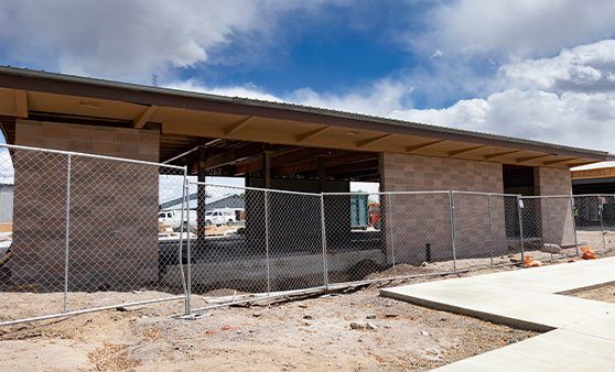 A building under construction with a chain link fence around it.