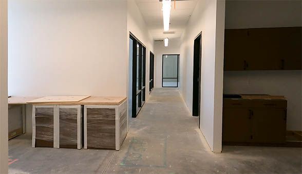 A long hallway in a building with a desk in the middle.