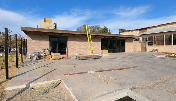 A large brick building is being built in a parking lot.