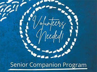 A blue sign that says volunteers needed on it