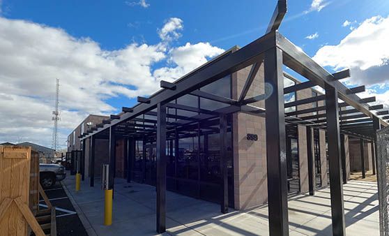 A building with a pergola on top of it and a blue sky in the background.