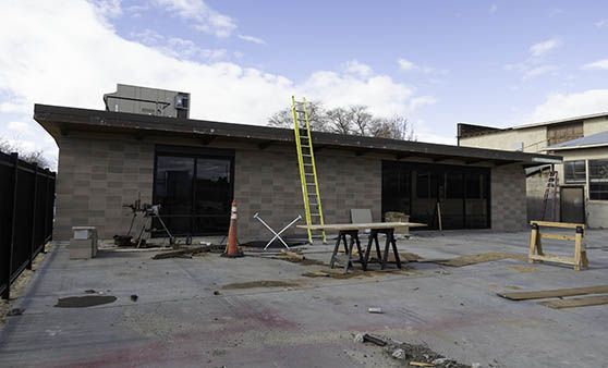 A building under construction with a ladder and a table in front of it.