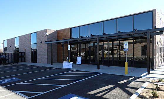 A large building with a lot of windows and a parking lot in front of it.