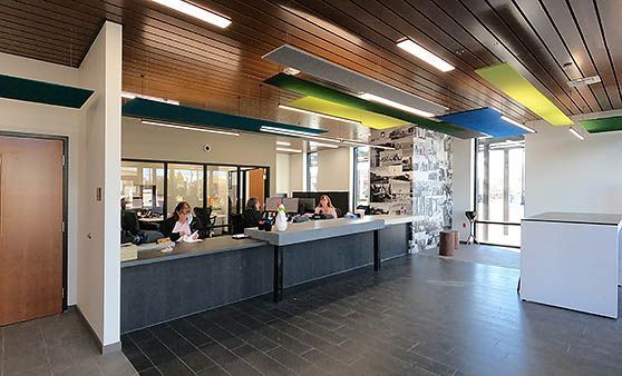 A group of people are sitting at a counter in a lobby.