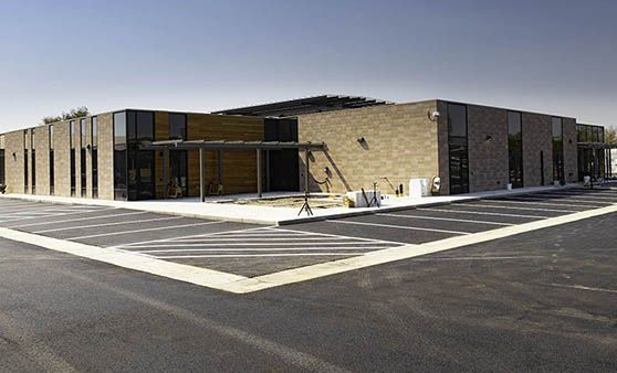 A large brick building with a parking lot in front of it.