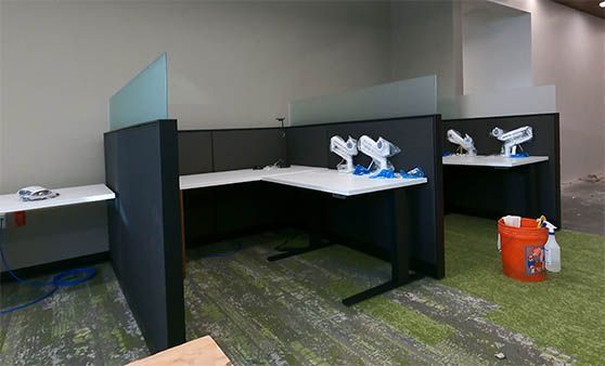 An empty office with cubicles and a bucket of cleaning supplies.