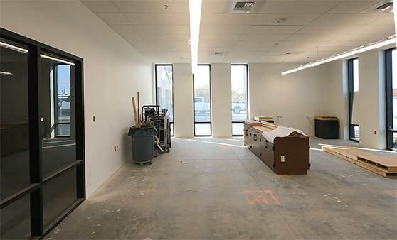 A large empty room with a lot of windows and a table.