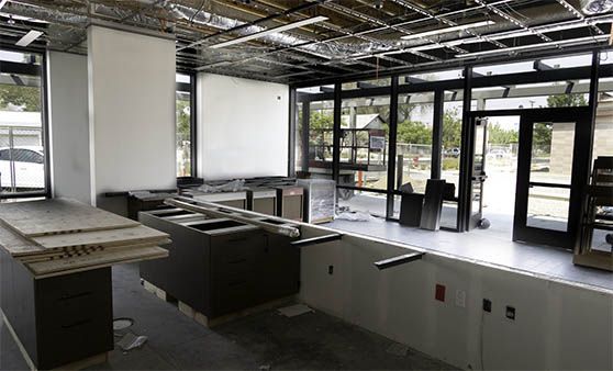 An empty room with a lot of windows and a door.