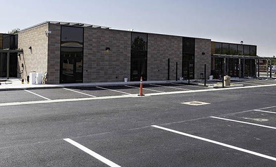 A brick building with a parking lot in front of it