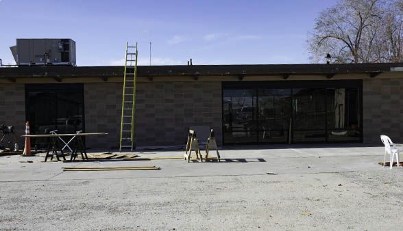 A building under construction with a ladder and a chair in front of it