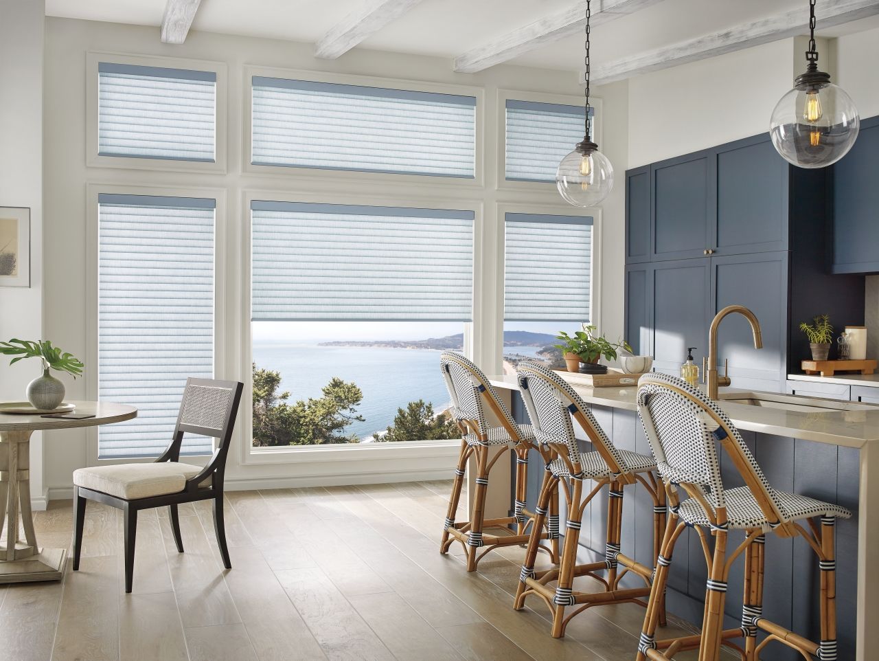 Energy-efficient cellular window shades installed on large kitchen windows with ocean view
