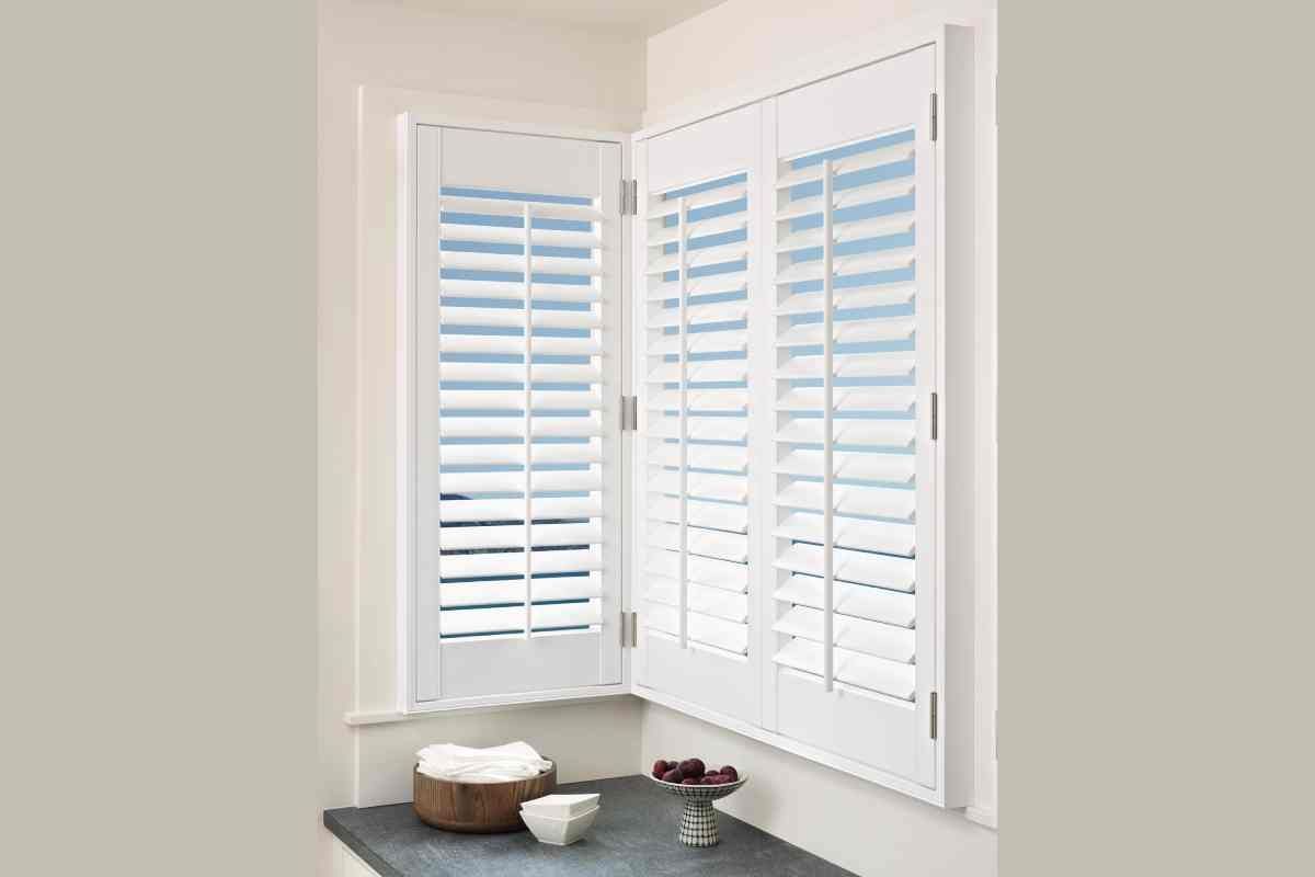 Hunter Douglas Palm Beach™ Polysatin™ Vinyl Shutters in the corner windows of a laundry room near Newton, Massachusetts (MA)