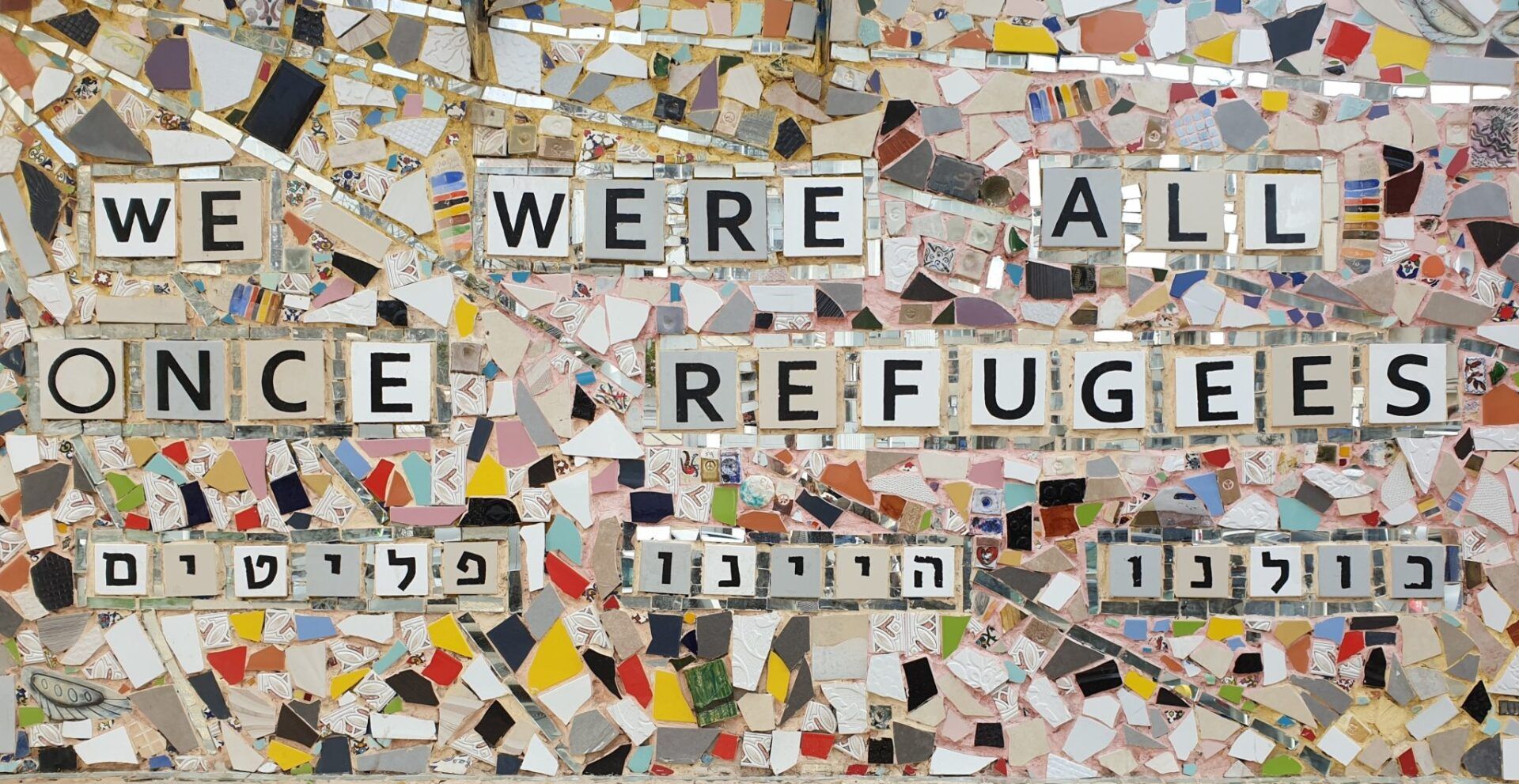 recorte de lajotas escrito ''we were all once refugees'' em tradução livre 