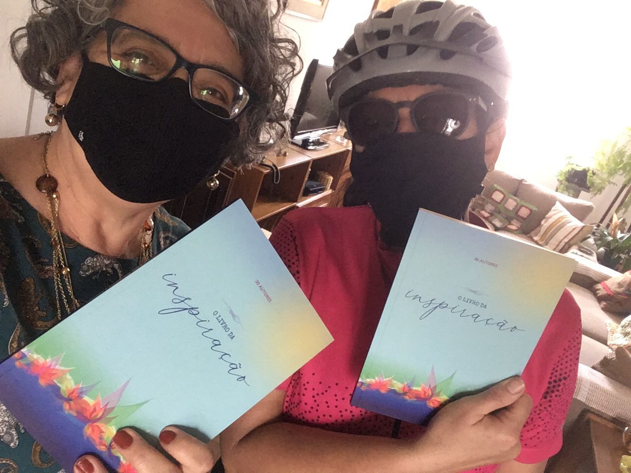 Silvia Angerami e Ana Monteiro, autora do livro, posam para foto com o livro. Ana está vestida com capacete e roupas de ciclista.