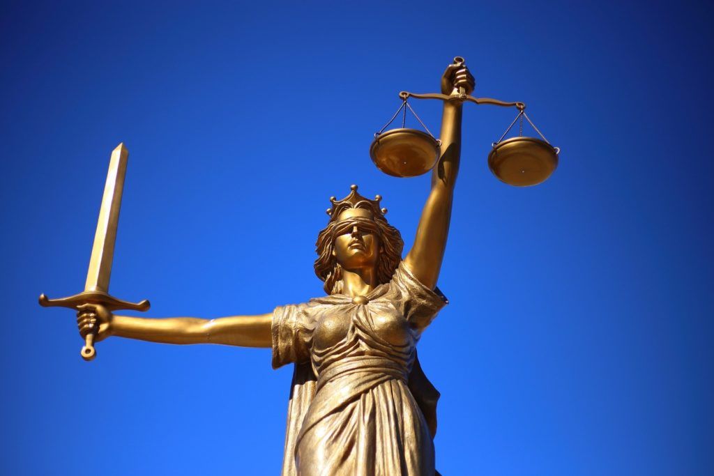 estátua representando a justiça com uma balança em uma mão, uma espada na outra e os olhos vendados