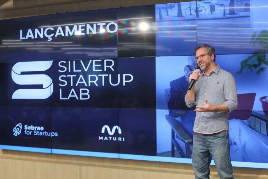 palestrante no Silver Startup Lab, é um homem, de óculos, está de pé e gesticulando com as mãos