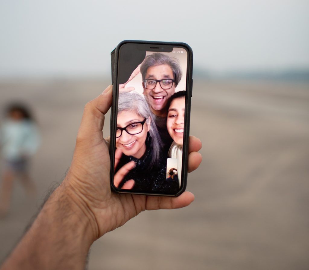 imagem mostra uma chamada de vídeo no celular, três pessoas estão falando com uma outra pessoa que tira a foto da chamada.