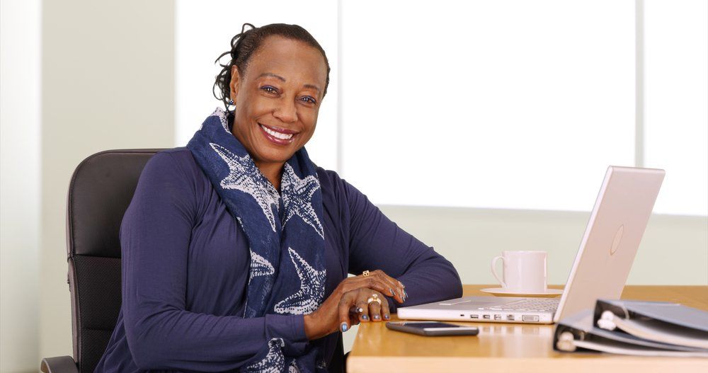 mulher negra, madura, sentada em frente a computador