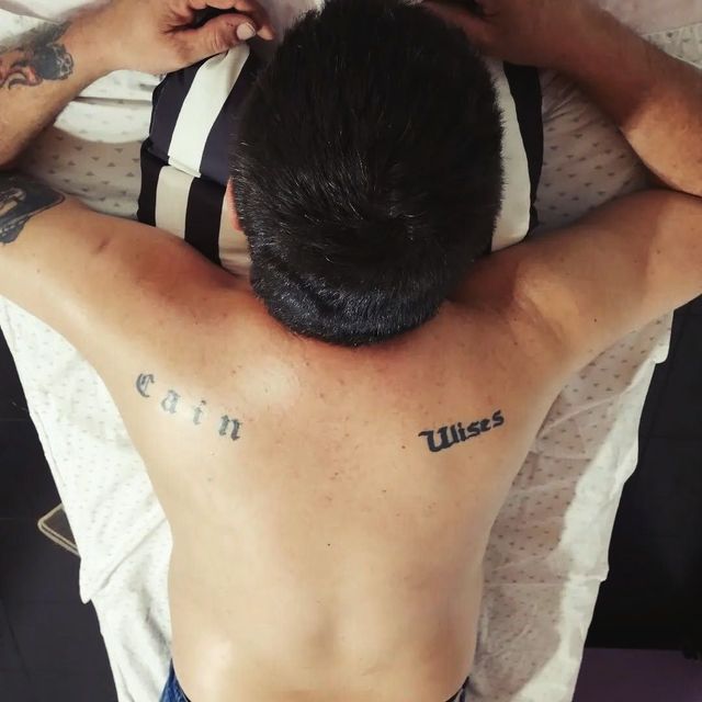 Un hombre con un tatuaje en la espalda que dice Caín.