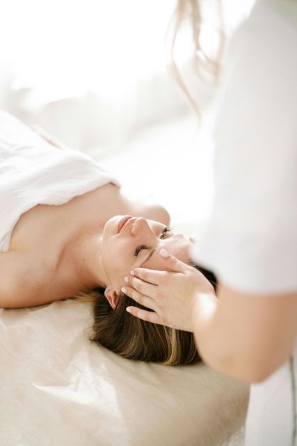 Una mujer está recibiendo un masaje en la cara en un spa.