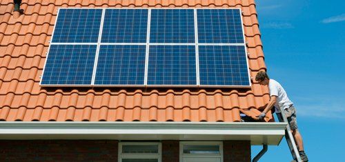 man on roof with solar panels