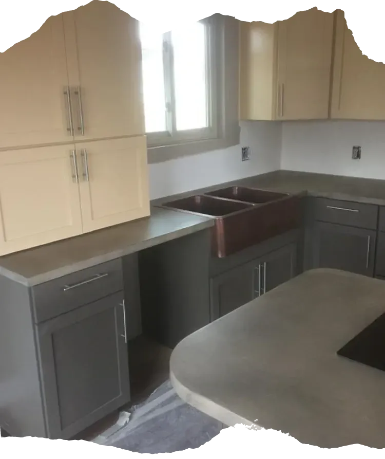 Gray and cream kitchen with concrete countertops and a copper sink.