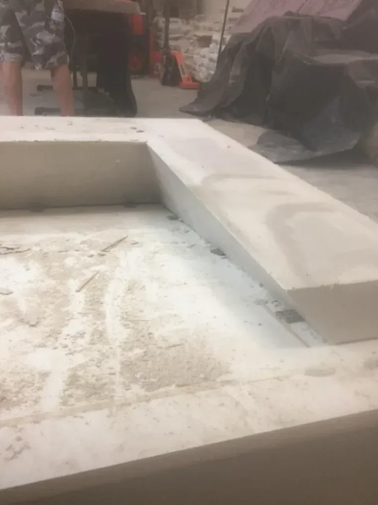 Concrete structure with a protruding section, dusty floor.