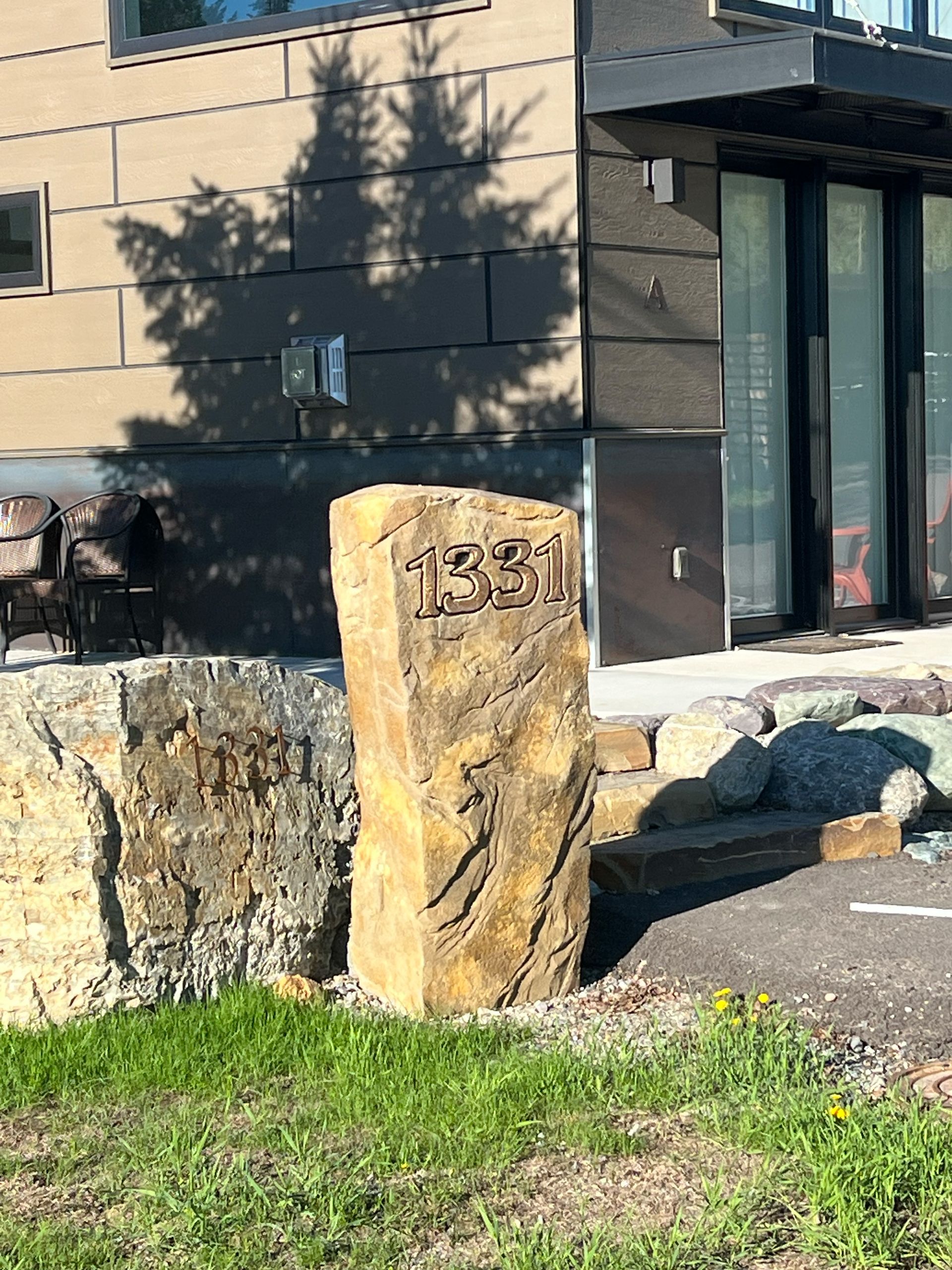 Stone marker with the number 1331 in front of a modern building.