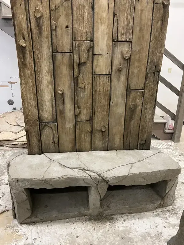 Wooden plank wall above a stone bench with two open compartments.