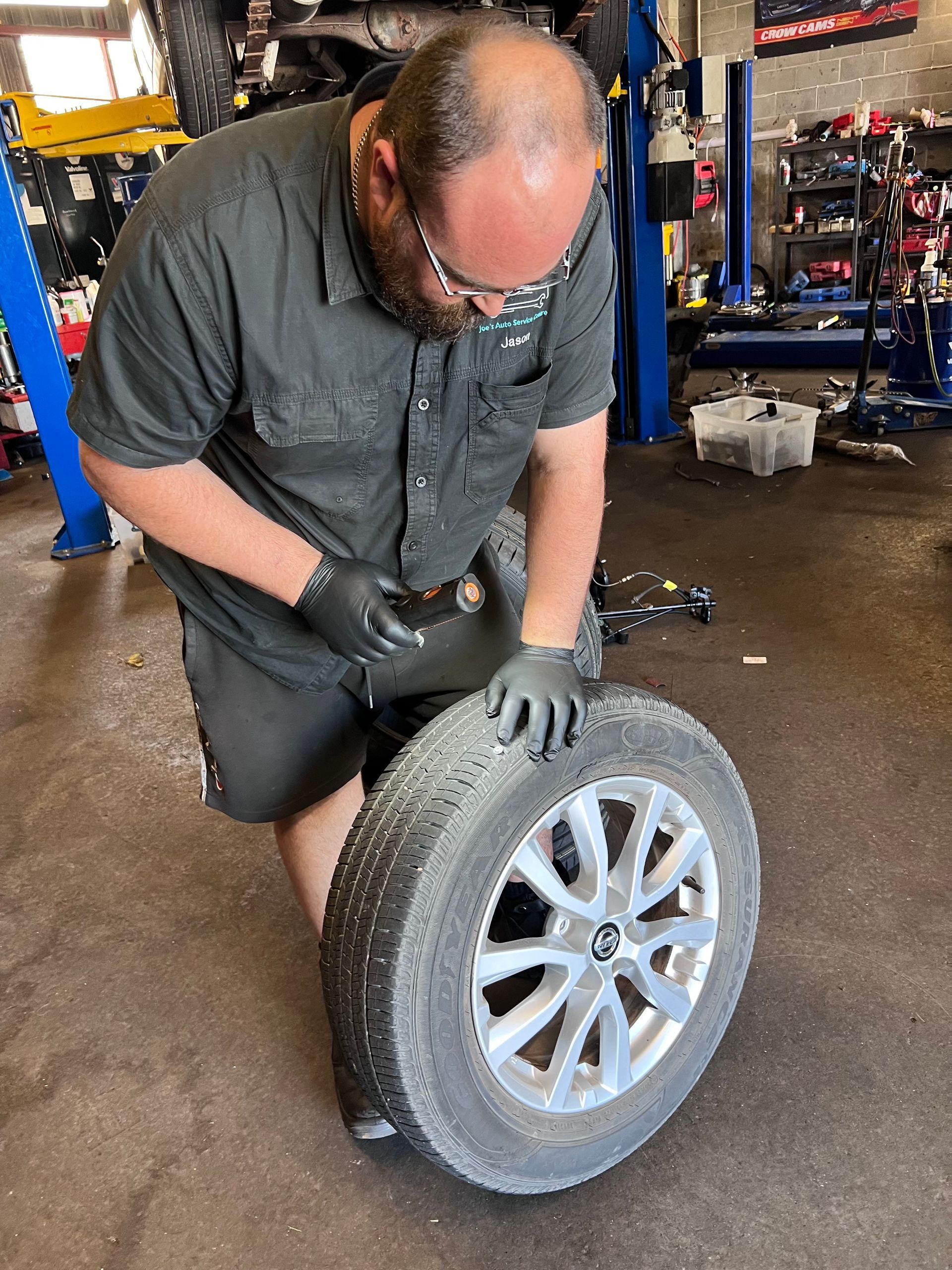 Man Repairing Tyre — Joe’s Auto Service Centre in Forster, NSW