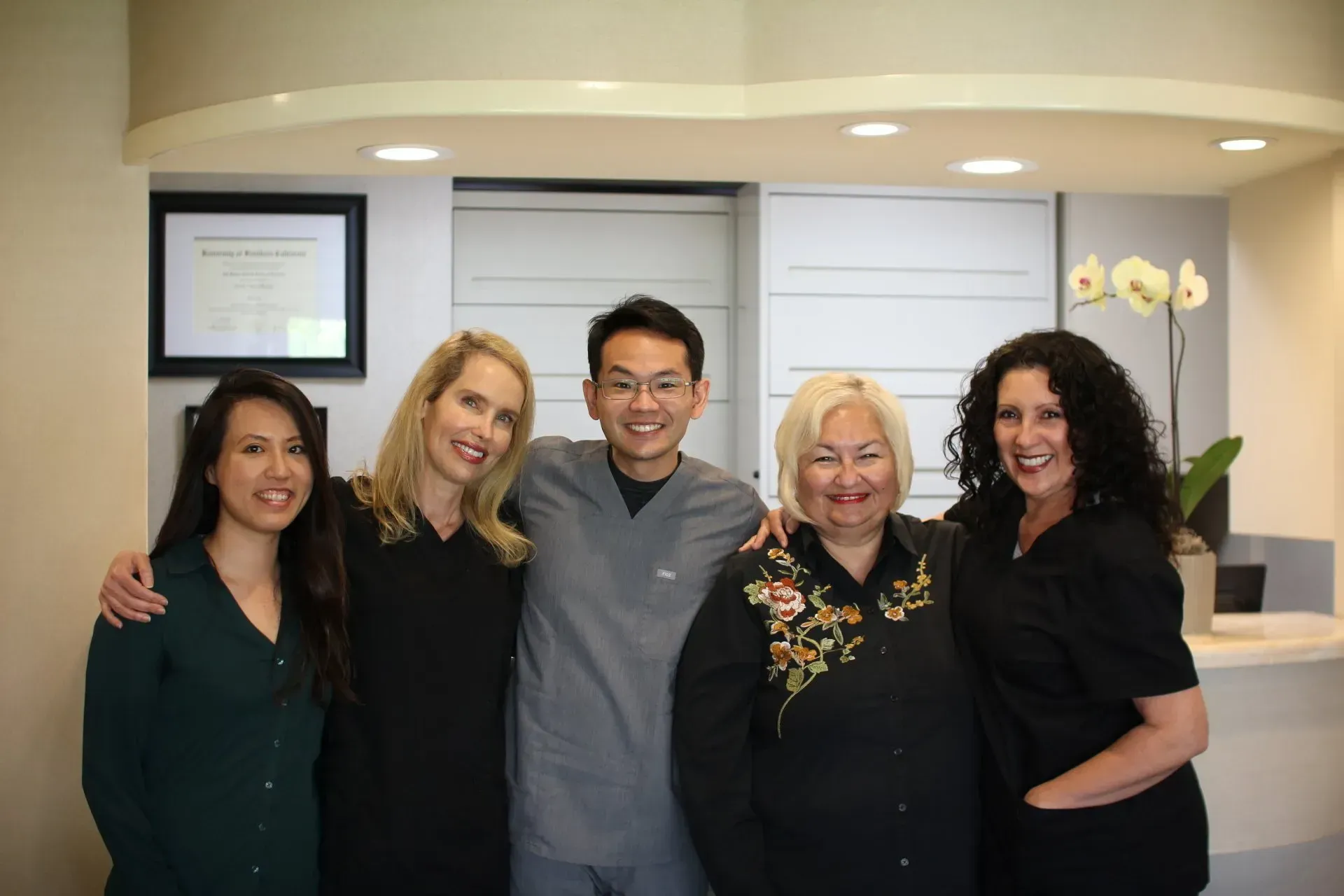 A group of people are posing for a picture in a dental office.
