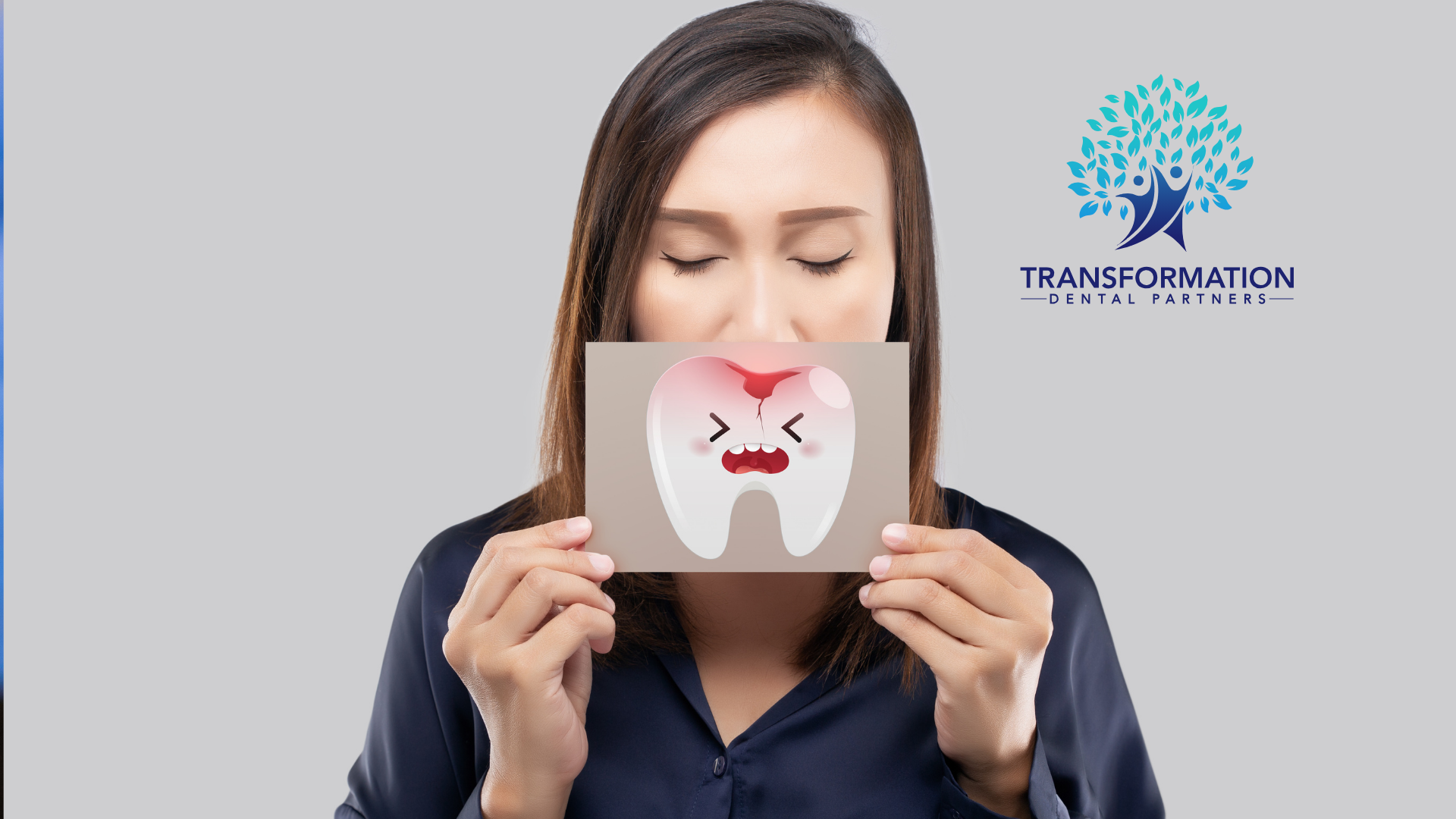 A woman is holding a piece of paper with a tooth on it.