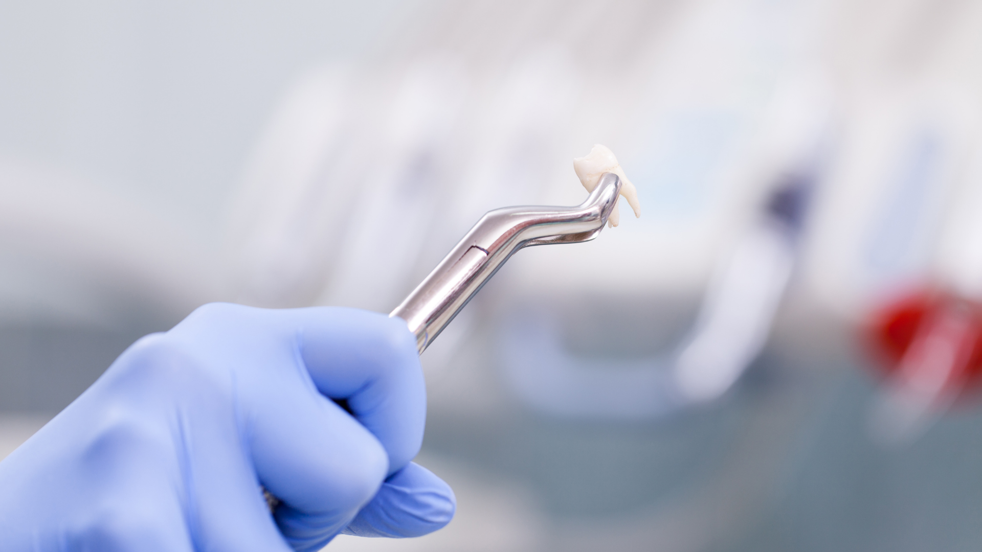 Gloved hand holding dental pick near a tooth in a clinical setting