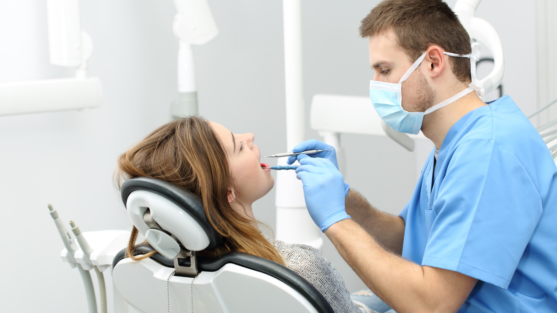 Dentist examining a patient's mouth in a dental office.