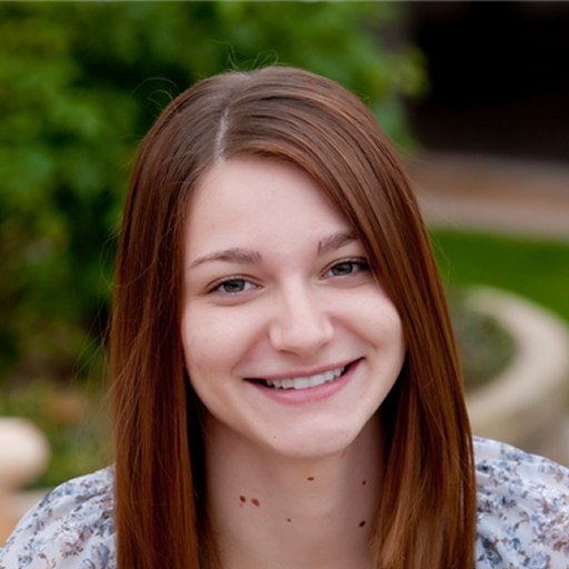 A woman with long brown hair is smiling for the camera