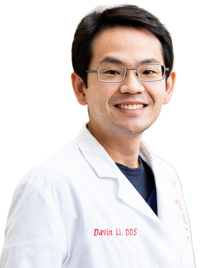 A man wearing glasses and a white coat is smiling for the camera.