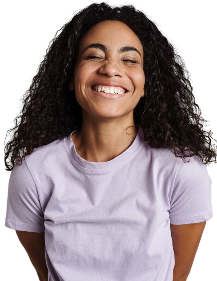 A woman with curly hair is wearing a purple shirt and smiling
