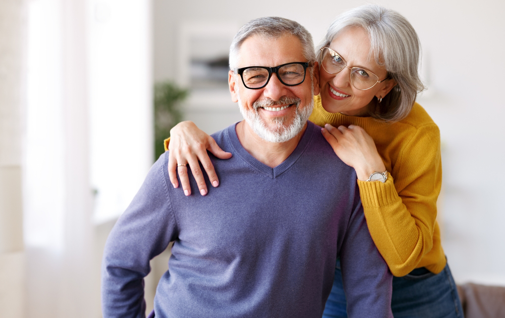 A woman is hugging a man in a living room.