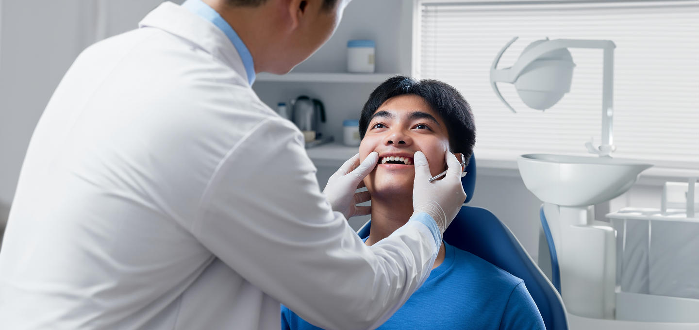 A dentist is examining a patient 's teeth in a dental office.