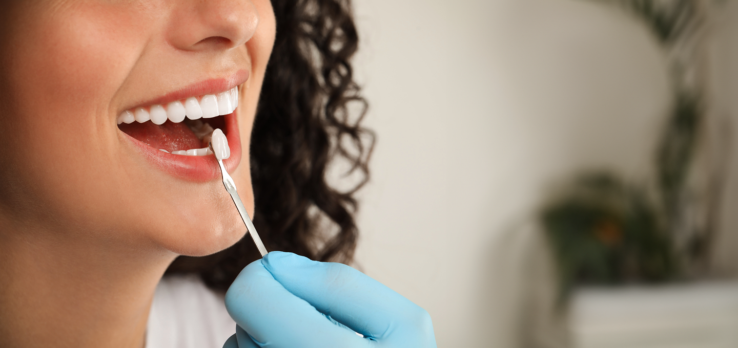 A woman is taking a sample from her mouth with a swab.