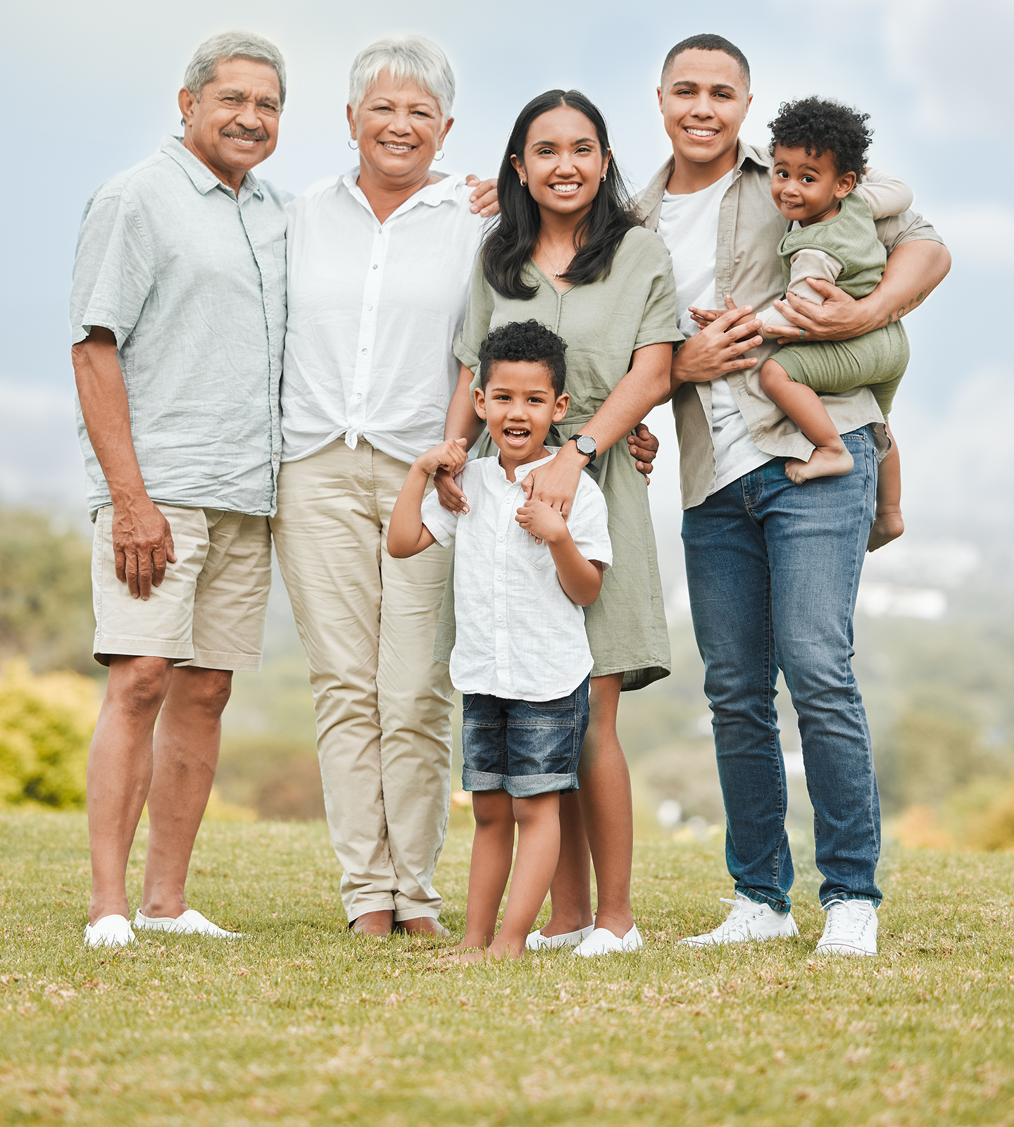 A family is posing for a picture in the grass.