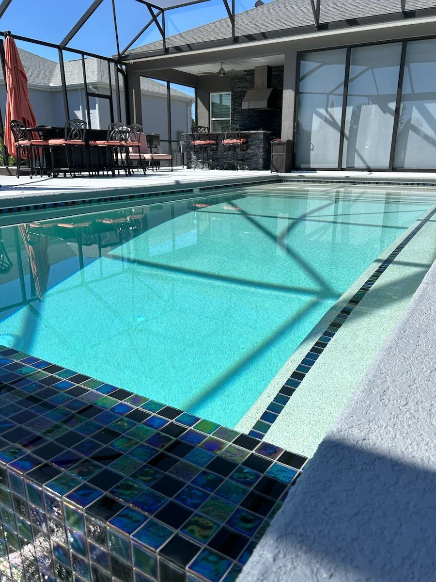 A large swimming pool with a house in the background